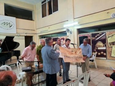 Festival de habaneras de La Habana. Enric Frigola, Presidente de la Fundación Ernest Morató, dona el cuadro-libro "Esencia habanera" del artista Josep Maria Alarcón, en presencia de Jesús Gómez Cairo, Director del Museo, Cecilio Tieles, Director Artístico del Festival y Presidente de Honor de ACC-I, Pere Doménech, de la Junta ACC-I y Antoni Mas. En el mismo se presentó  el libro "A peu de Muralla" de Pere Lluís Doménech6 de noviembre 2019, Museo Nacional de la Música, La Habana, Cuba